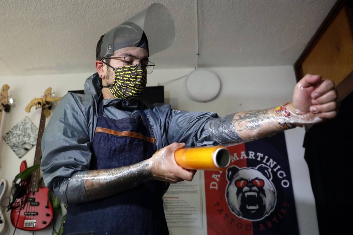 Guantes, mascarilla, escudo facial, traje de bioseguridad y forros de plástico hacen parte de las medidas contra el COVID-19 antes de realizar un tatuaje.