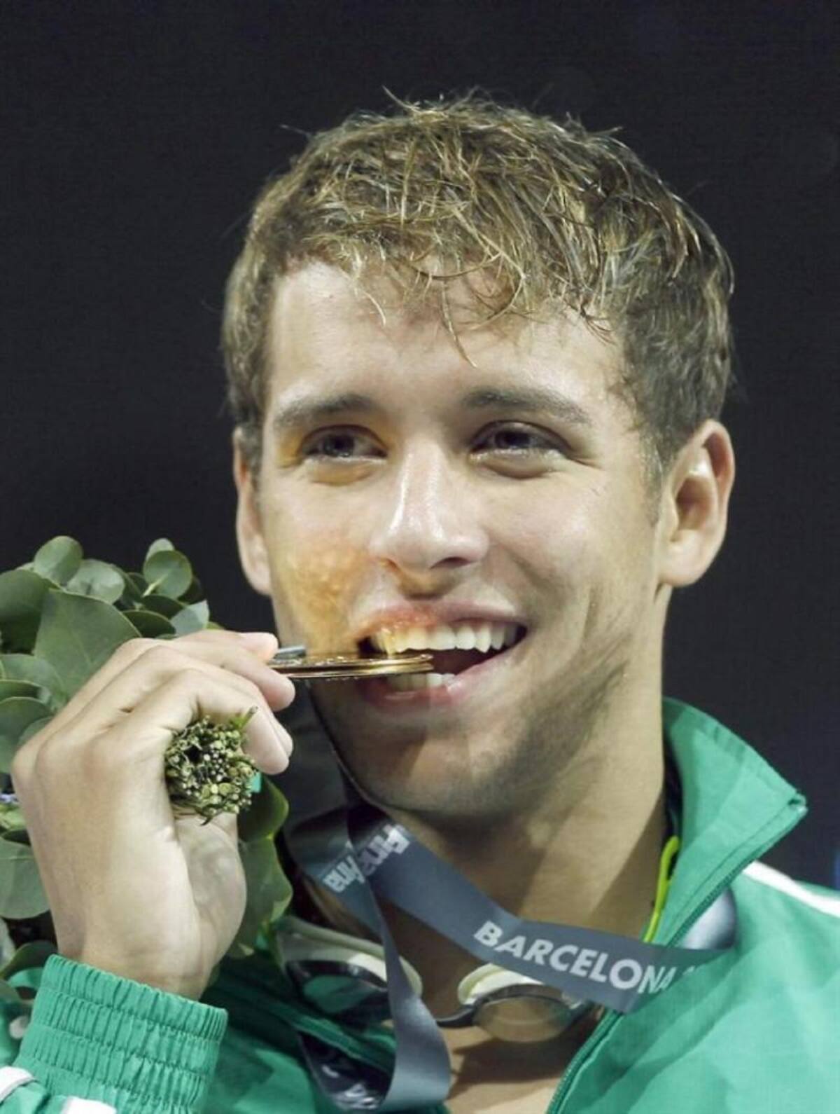 El sudafricano Chad Le Clos muerde la medalla de oro tras vencer en la final de los 200m mariposa masculinos de los Campeonatos del Mundo de Natación disputado este 31 de julio en las Piscinas Picornell de Barcelona.