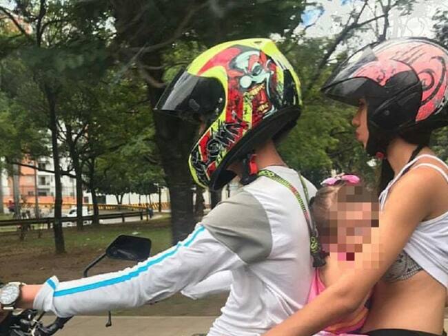 Mujer amamanta a su hija en una motocicleta que va en movimiento