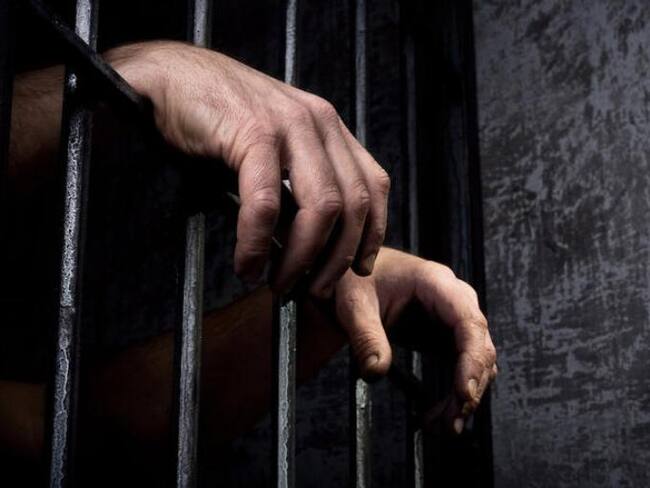 Imagen subjetiva de cárcel. Manos entre una reja de un centro penitenciario. Cortesía: Getty Imágenes