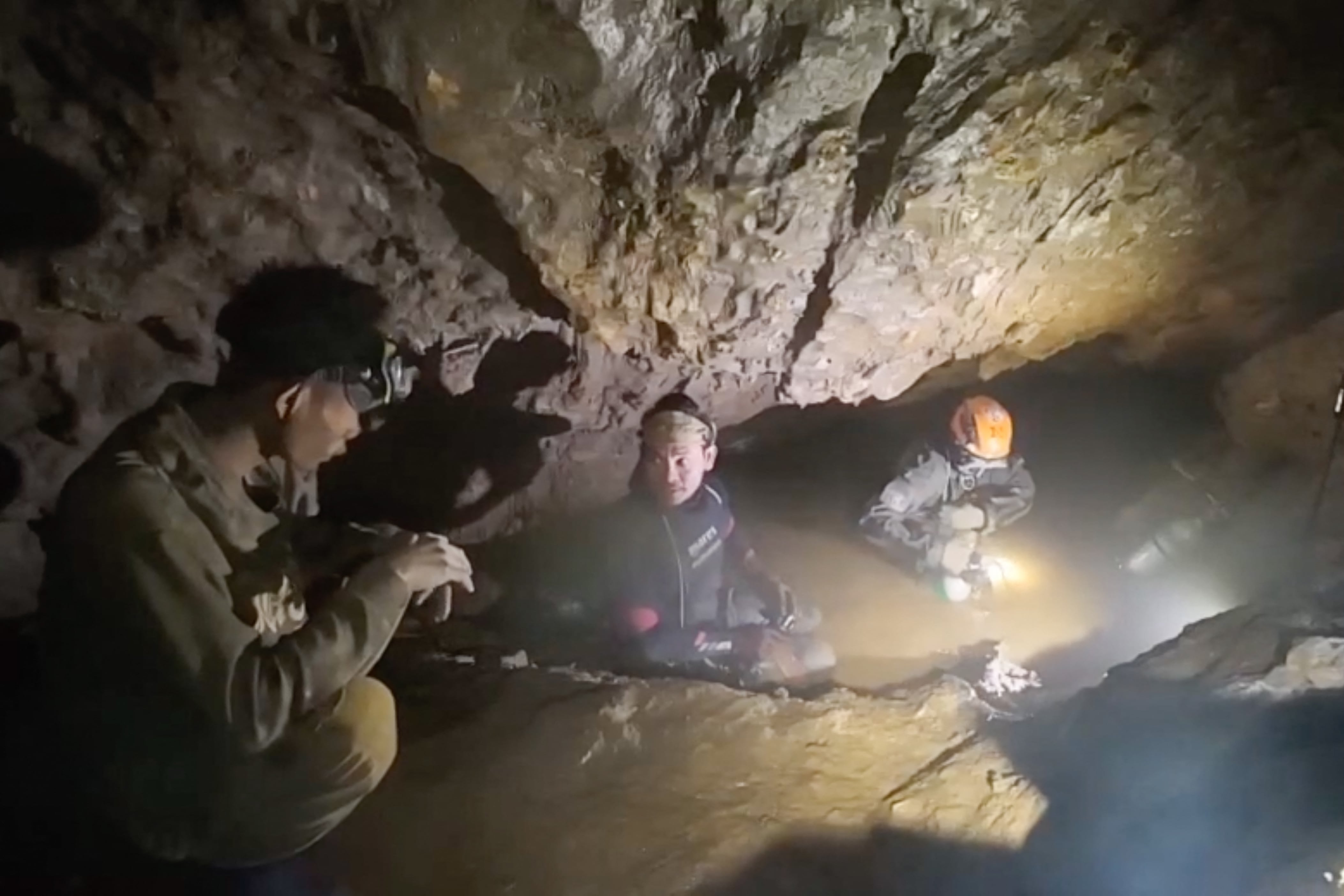 Esta captura de pantalla, tomada de un video facilitado el 29 de mayo de 2026 y proporcionado por Benz Norrased Palasing de Seascout Diving, muestra a un equipo de rescate (C, D) a punto de liberar a uno (I) de los siete hombres atrapados en una cueva semisumergida en la provincia central de Xaysomboun, al noreste de la capital, Vientiane. Un equipo de rescate liberó el 29 de mayo a uno de los siete hombres atrapados dentro de una cueva semisumergida en Laos durante más de una semana, según informó el grupo que trabajaba en el lugar. (Foto de HANDOUT / Benz Norrased Palasing / Seascout Diving / AFP) / ----NOTA DEL EDITOR --- RESTRINGIDO AL USO EDITORIAL - CRÉDITO OBLIGATORIO "AFP PHOTO / Benz Norrased Palasing / Seascout Diving" - PROHIBIDO SU USO EN MARKETING - PROHIBIDA SU CAMPAÑA PUBLICITARIA - DISTRIBUIDO COMO UN SERVICIO A LOS CLIENTES - PROHIBIDO SU ARCHIVO
