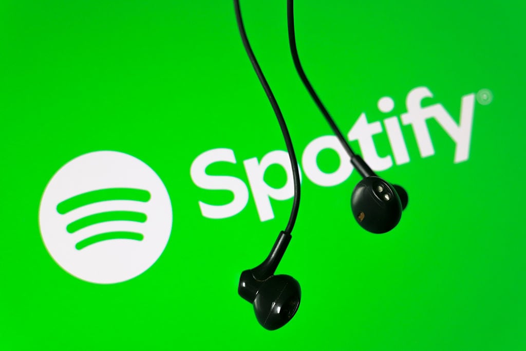 The Spotify logo appears on the screen and a headset in this photo illustration in Ontario, Canada, on February 13, 2026. (Photo by Thomas Fuller/NurPhoto via Getty Images)