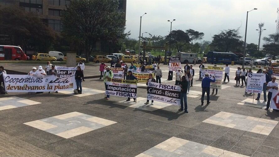 Los damnificados por la millonaria estafa de Elite en Colombia protestan a las afueras del búnker de la Fiscalía General de la Nación. Foto: Laura Palomino (W Radio)
