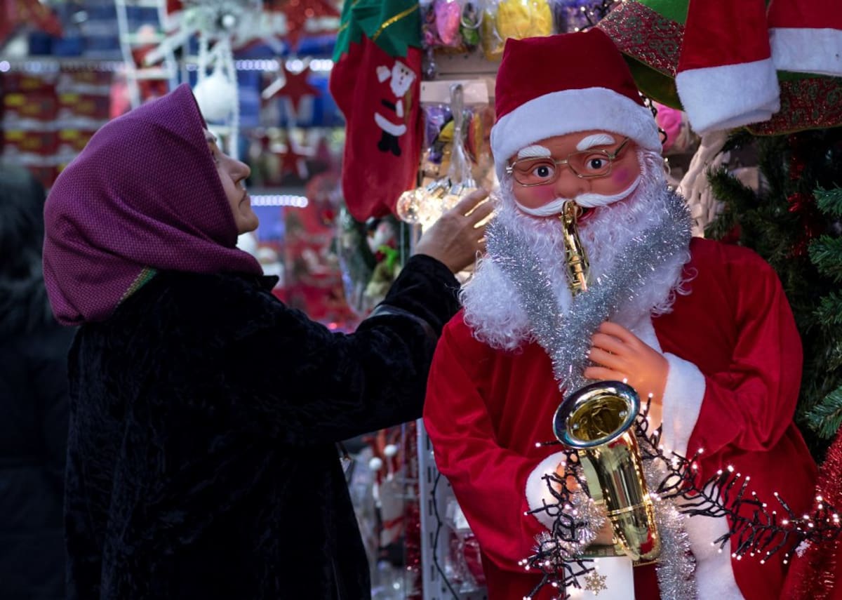 Varias personas realizan sus compras en un mercado decorado con motivos navideños en Estambul (Turquía)
