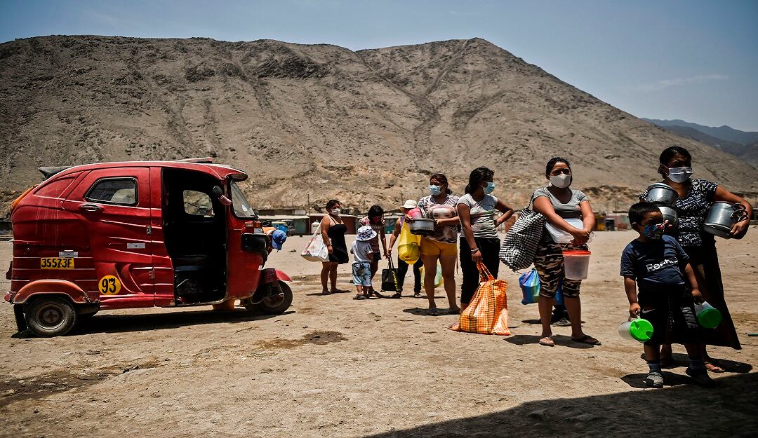 Una comunidad de Comas, al norte de Lima (Perú), mantiene la distancia mientras espera recibir alimentación.