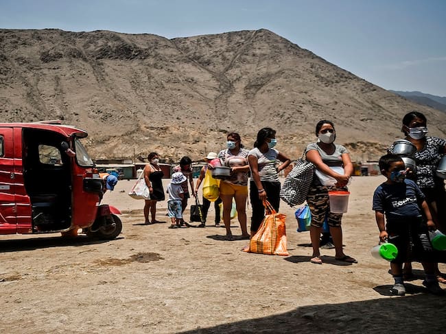 Una comunidad de Comas, al norte de Lima (Perú), mantiene la distancia mientras espera recibir alimentación.
