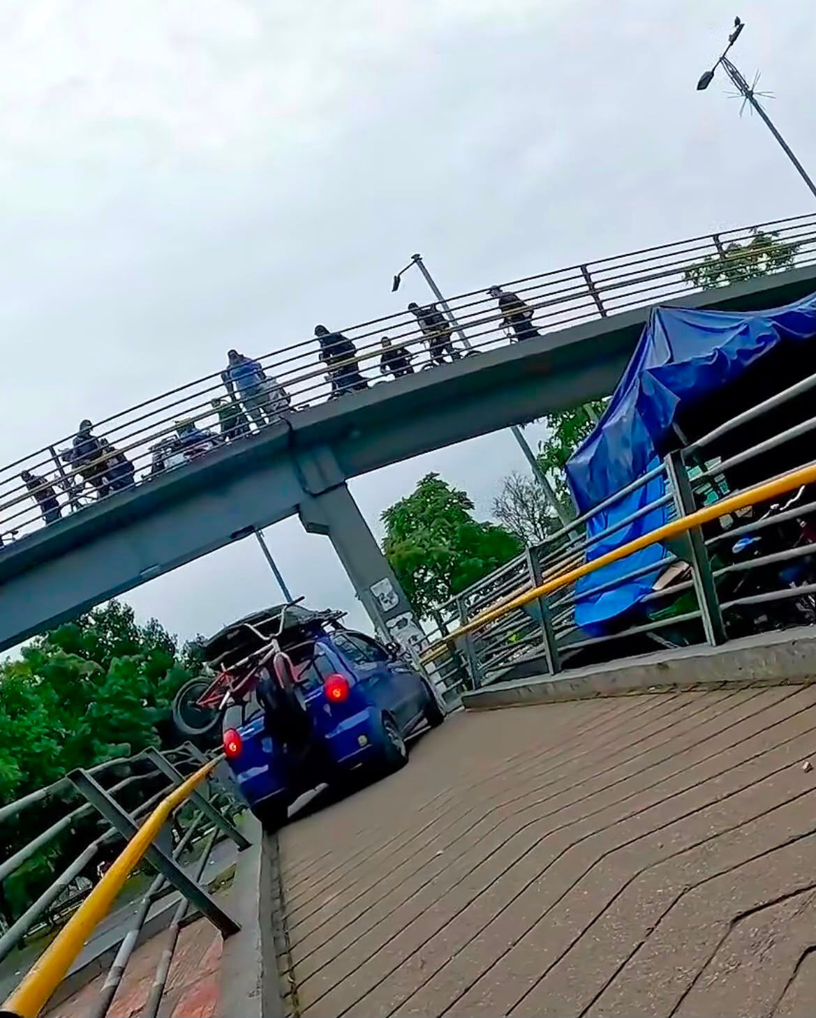 Autoridades identificaron al vehículo azul que subió a un puente peatonal en Bogotá