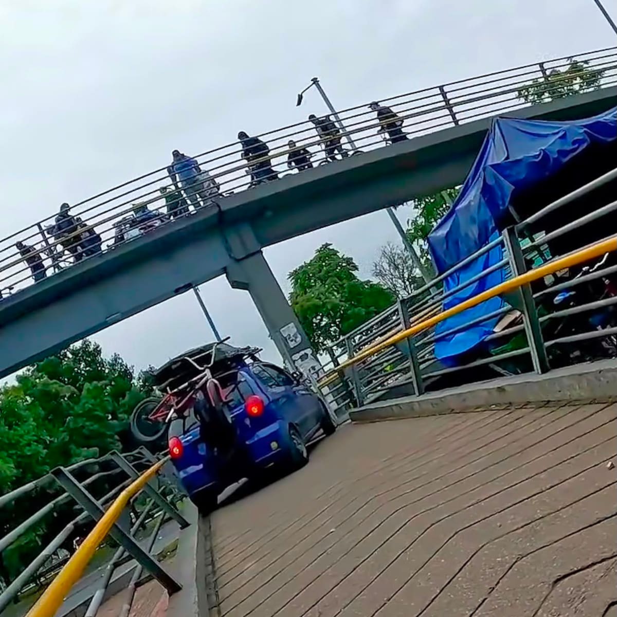Autoridades identificaron al vehículo azul que subió a un puente peatonal en Bogotá