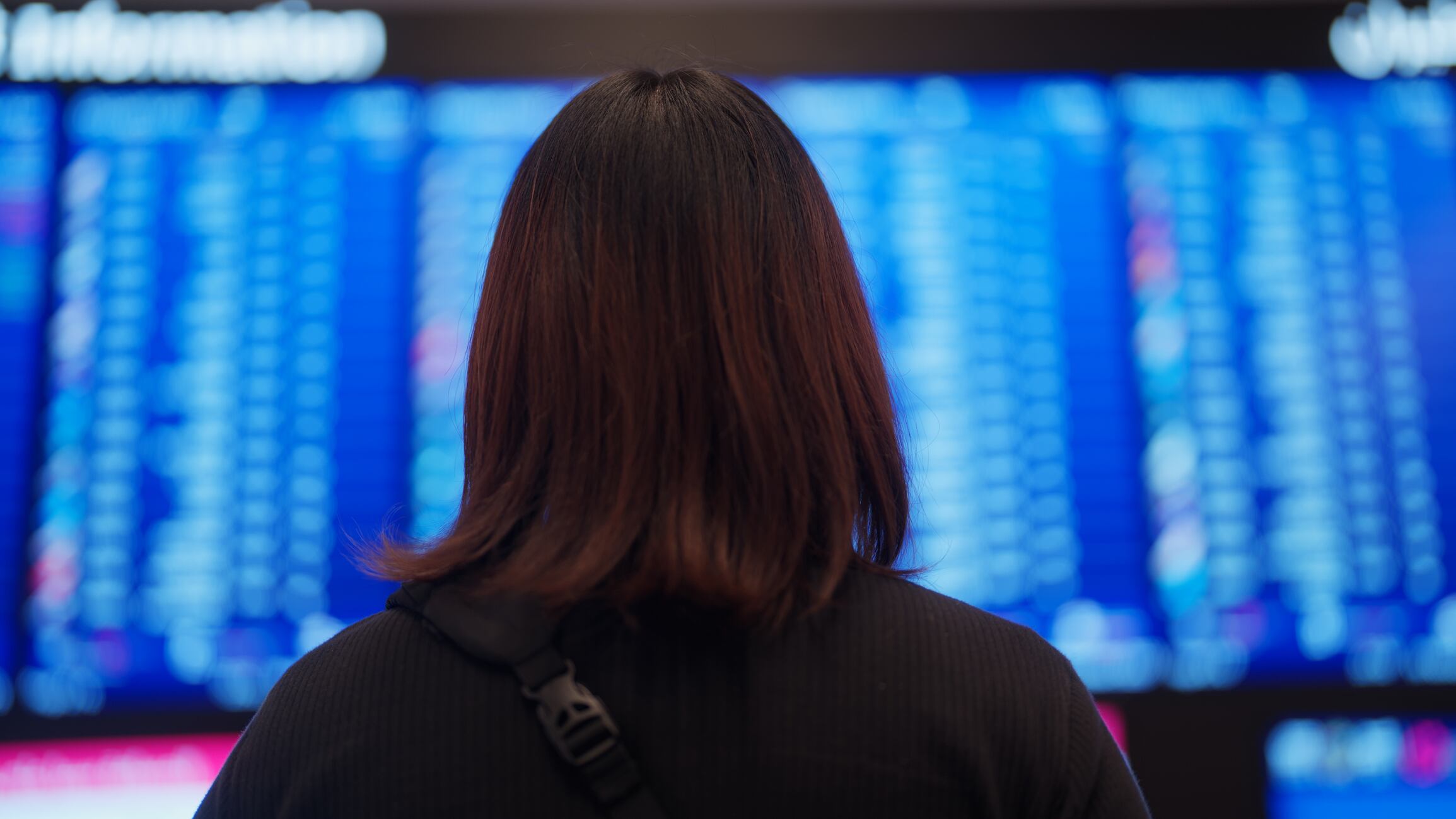 Mujer viendo los vuelos en aeropuerto // Getty Images
