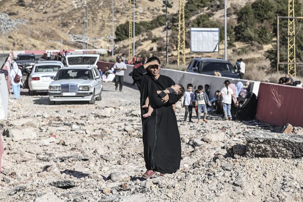 Syrians and Lebanese living in Lebanon cross to Syria side with their belongings they could take with them at Masnaa Border Crossing after the Israeli attacks in Massna, Lebanon on October 4, 2024. Families had difficulties crossing the roads, which were largely destroyed by Israeli airstrikes. (Photo by Murat Sengul/Anadolu via Getty Images)