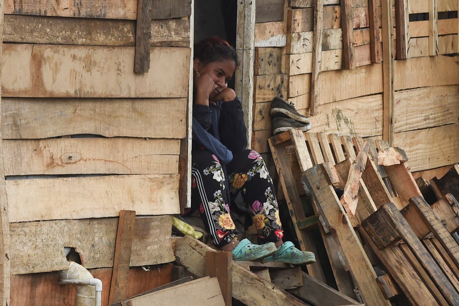 A woman remains sitting at her home of the Moravia neighborhood as local authorities try to implement an eviction order to evacuate families living in alleged illegal constructions, in Medellin, Colombia, on November 3, 2021. - The Moravia neighborhood is known for having been built on a garbage dump and for being from where late drug lord Pablo Escobar set up his first political campaign, and where he helped to build a football field and to install the electric network. (Photo by JOAQUIN SARMIENTO / AFP) (Photo by JOAQUIN SARMIENTO/AFP via Getty Images)