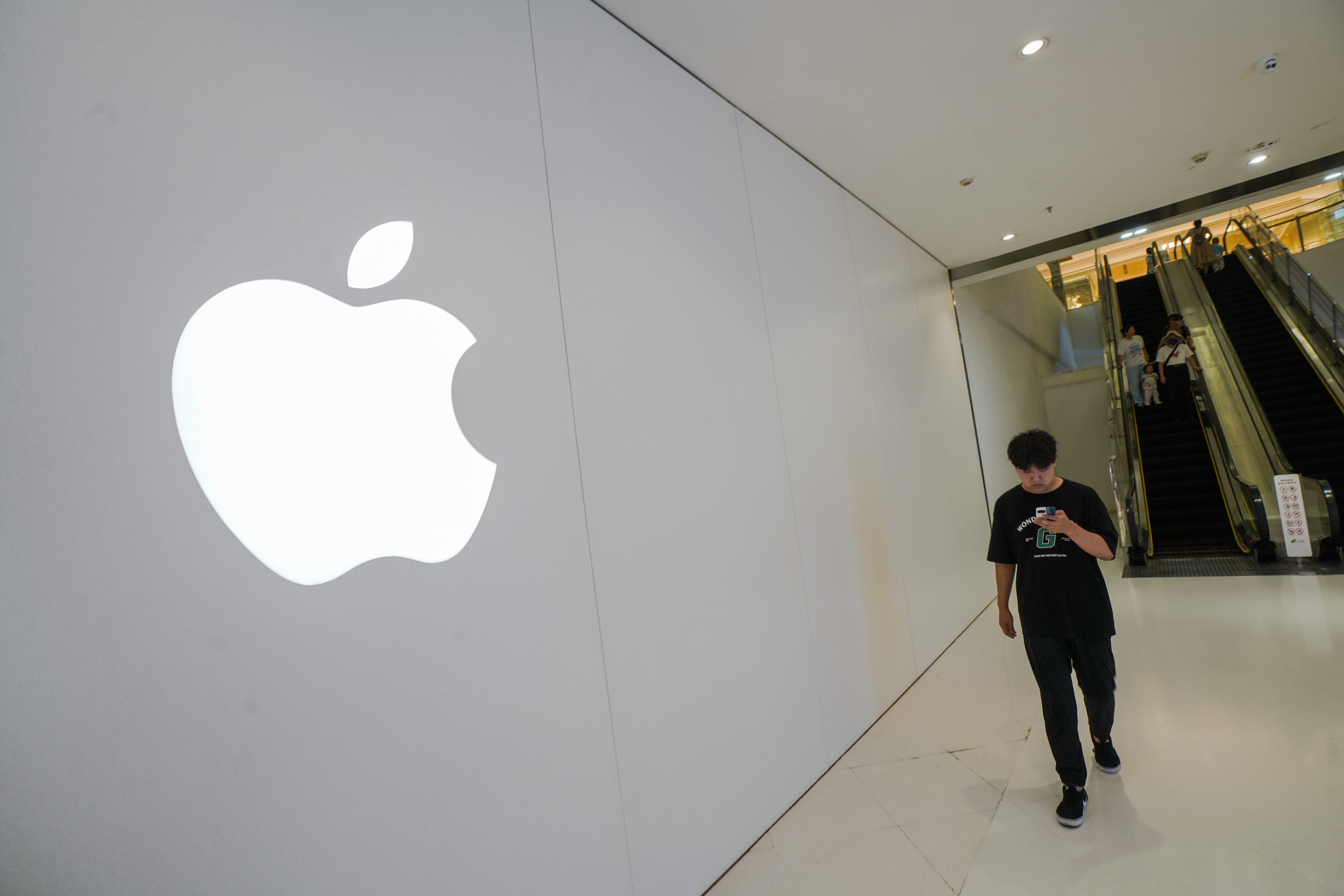 Beijing (China), 07/09/2023.- A man walks beside an Apple store at a mall in Beijing, China, 07 September 2023. China demanded officials at central government agencies stop using Apple's iPhones and other foreign-branded devices at work, and the cease bringing them into the office, according to the Wall Street Journal's report on 06 September. EFE/EPA/WU HAO