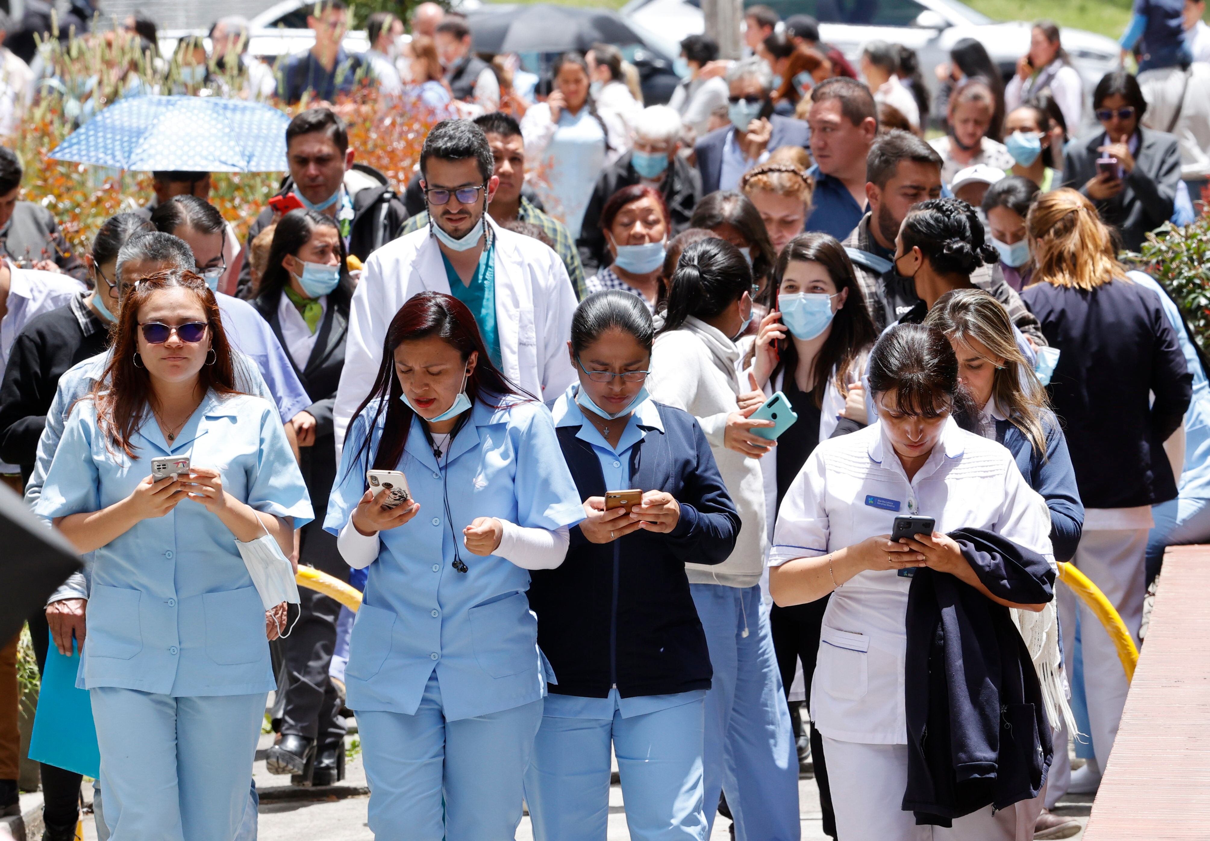 AME2063. BOGOTÁ (COLOMBIA), 17/08/2023.- Personas se reúnen afuera de un edificio luego de ser evacuadas debido a un sismo de 6.1 hoy, en Bogotá (Colombia). Un temblor de magnitud 6,1 sacudió al mediodía de este jueves buena parte de Colombia, sin que hasta el momento las autoridades hayan informado de víctimas o daños. EFE/ Mauricio Dueñas Castañeda