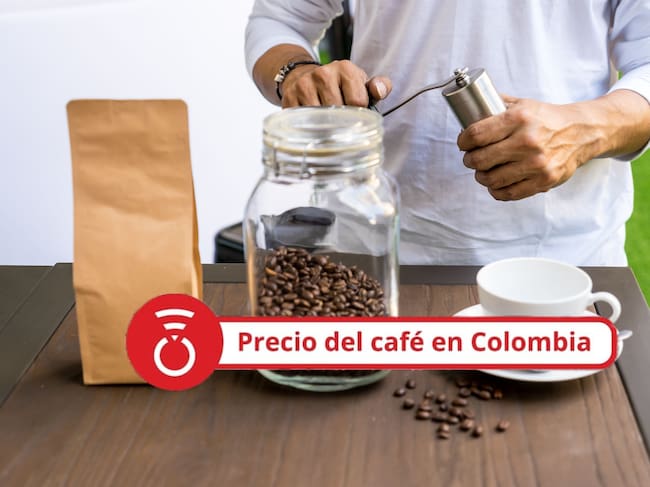 Persona moliendo café con molinillo de café manual al lado del desenfoque de la bolsa de papel marrón en blanco en primer plano. Foto Getty Images