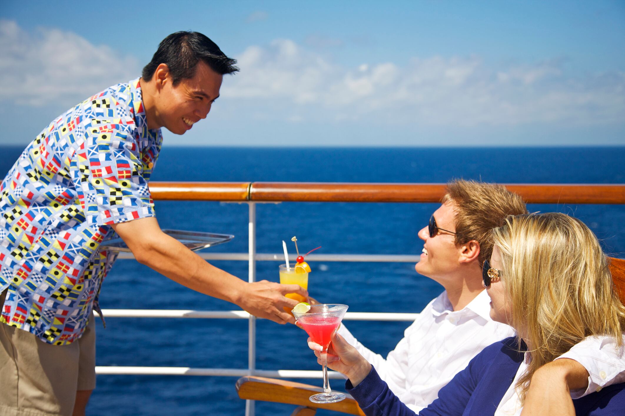 Pareja recibiendo cocteles en un crucero de uno de los trabajadores de la embarcación (Getty Images)