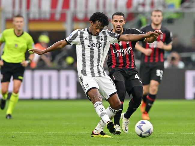 MILAN, ITALY - OCTOBER 08: Juan Cuadrado of Juventus challenged by Ismael Bennacer of AC Milan during the Serie A match between AC Milan and Juventus at Stadio Giuseppe Meazza on October 8, 2022 in Milan, Italy. (Photo by Chris Ricco/Getty Images)