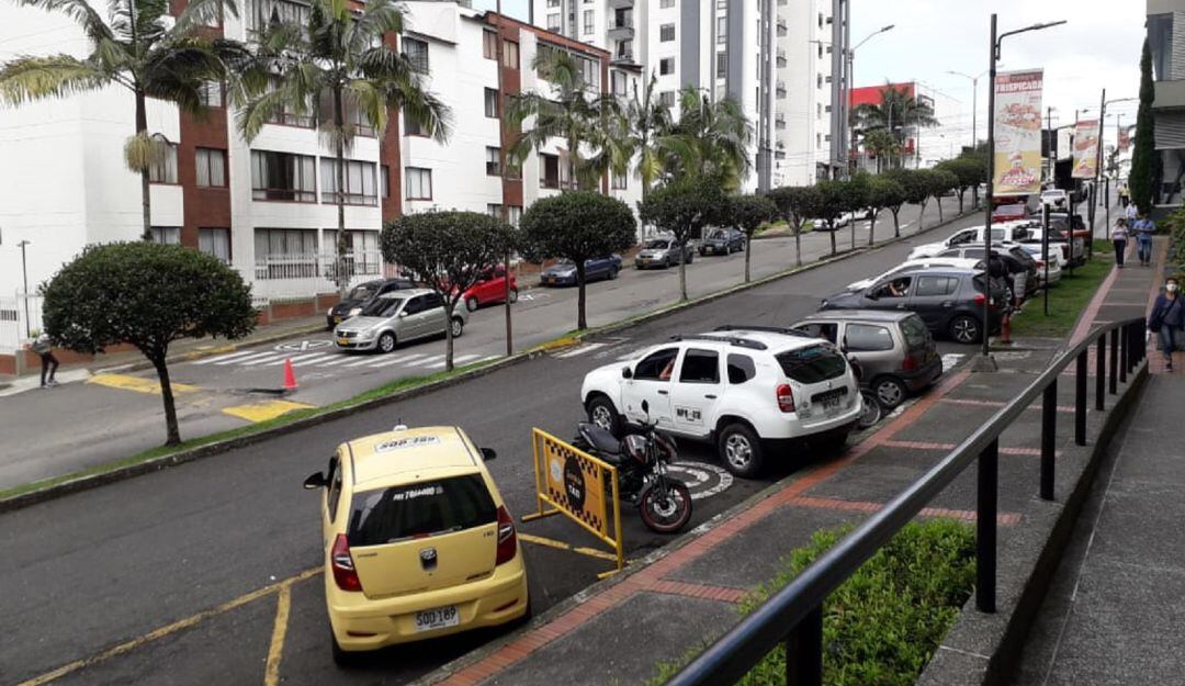 Calle para ingresar al Centro Comercial Portal del Quindío, al fondo sobre el reductor un gran hueco en la vía