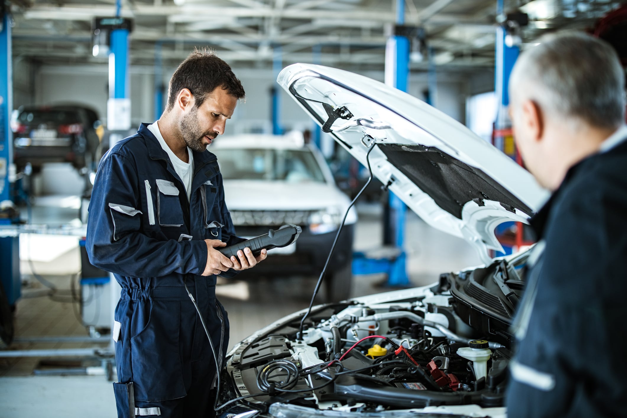 Mecánico de automóviles trabajando con la herramienta de diagnóstico de automóviles en un taller de reparación (Getty Images)