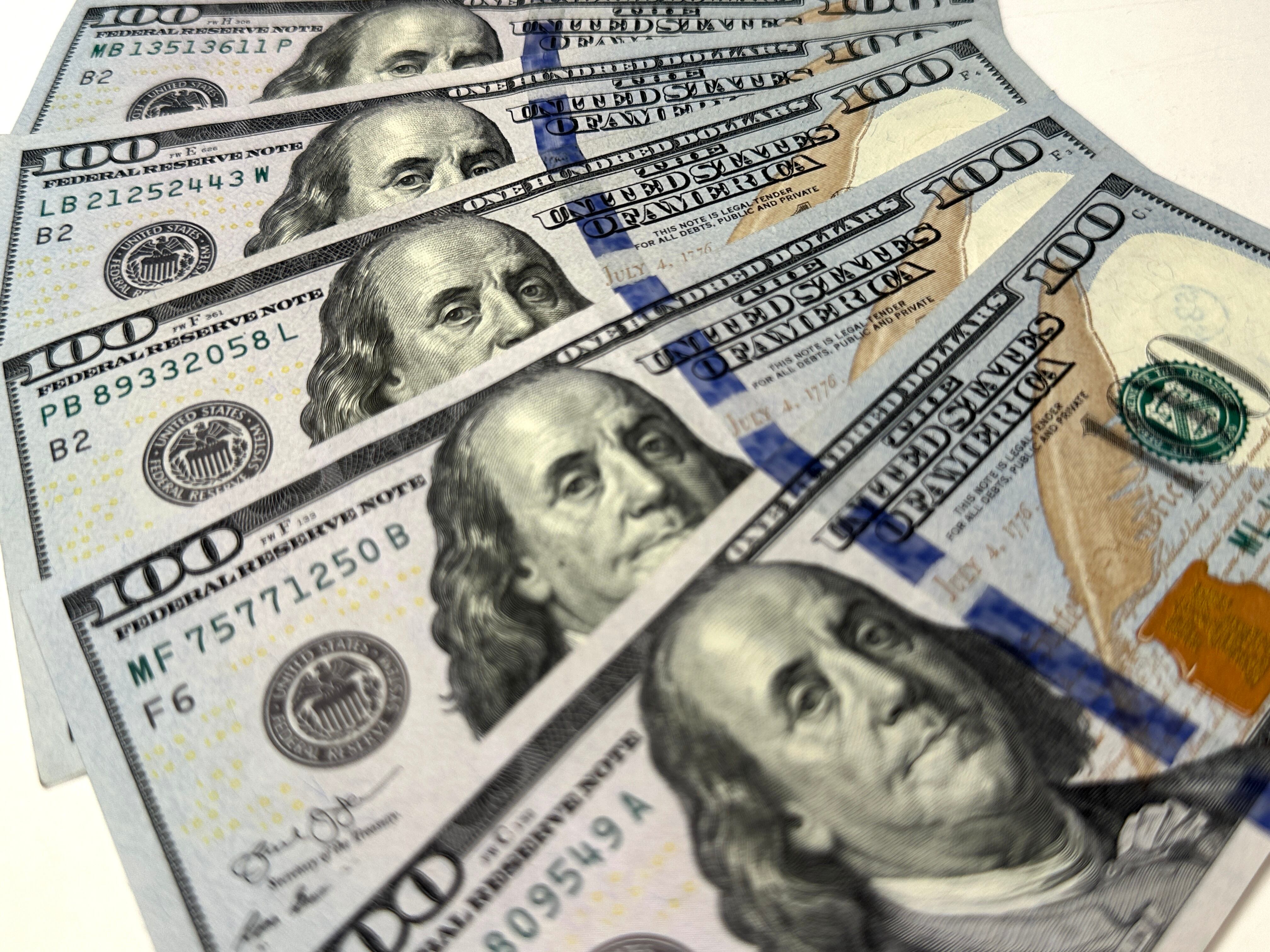 Imagen ilustrativa de varios billetes de 100 dólares regados alrededor (Crédito: Getty Images)