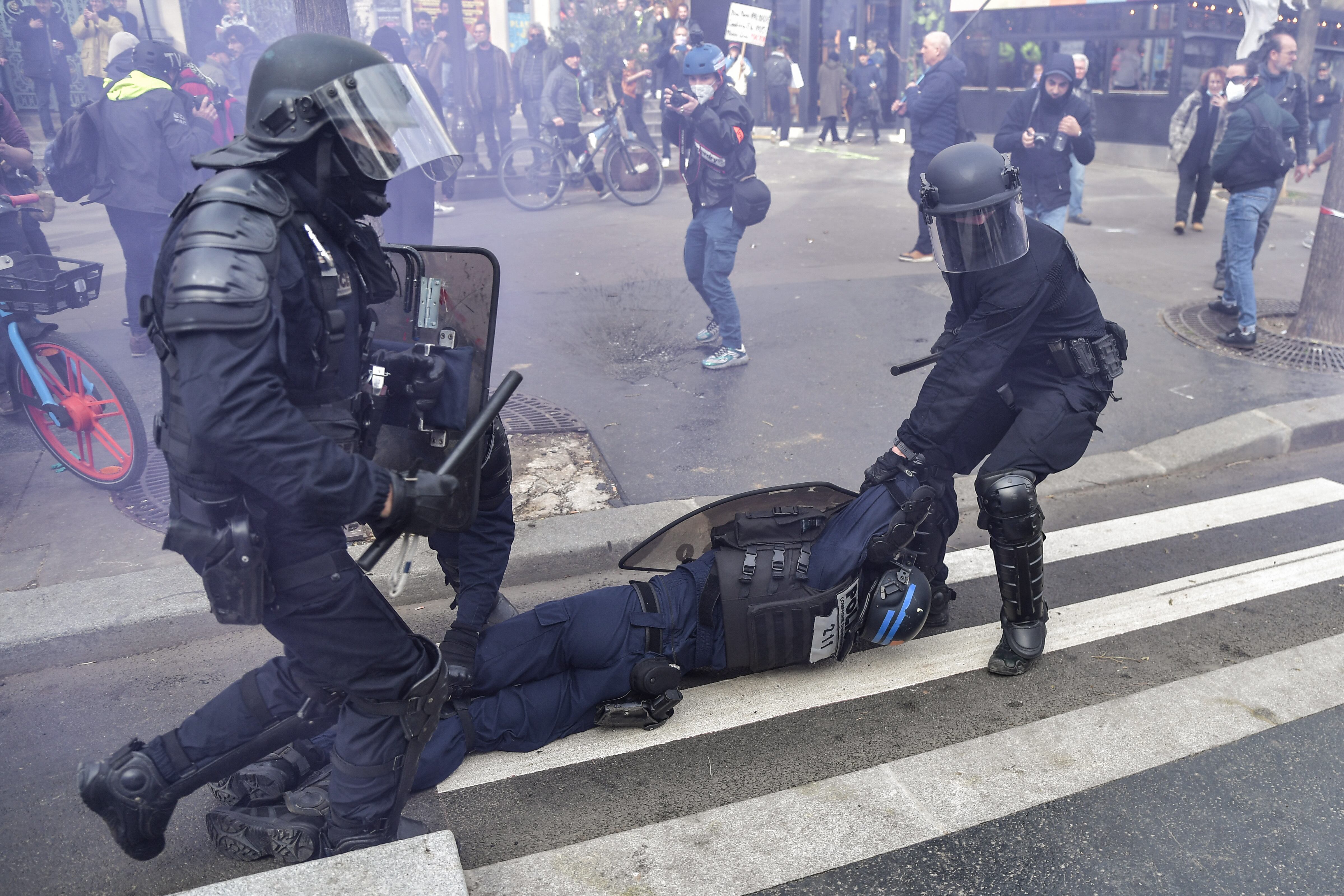 Policías antidisturbios intentan llevar un uniformado desmallado en medio de las protestas sociales en Francia. 
(Foto: Firas Abdullah/Anadolu Agency via Getty Images)