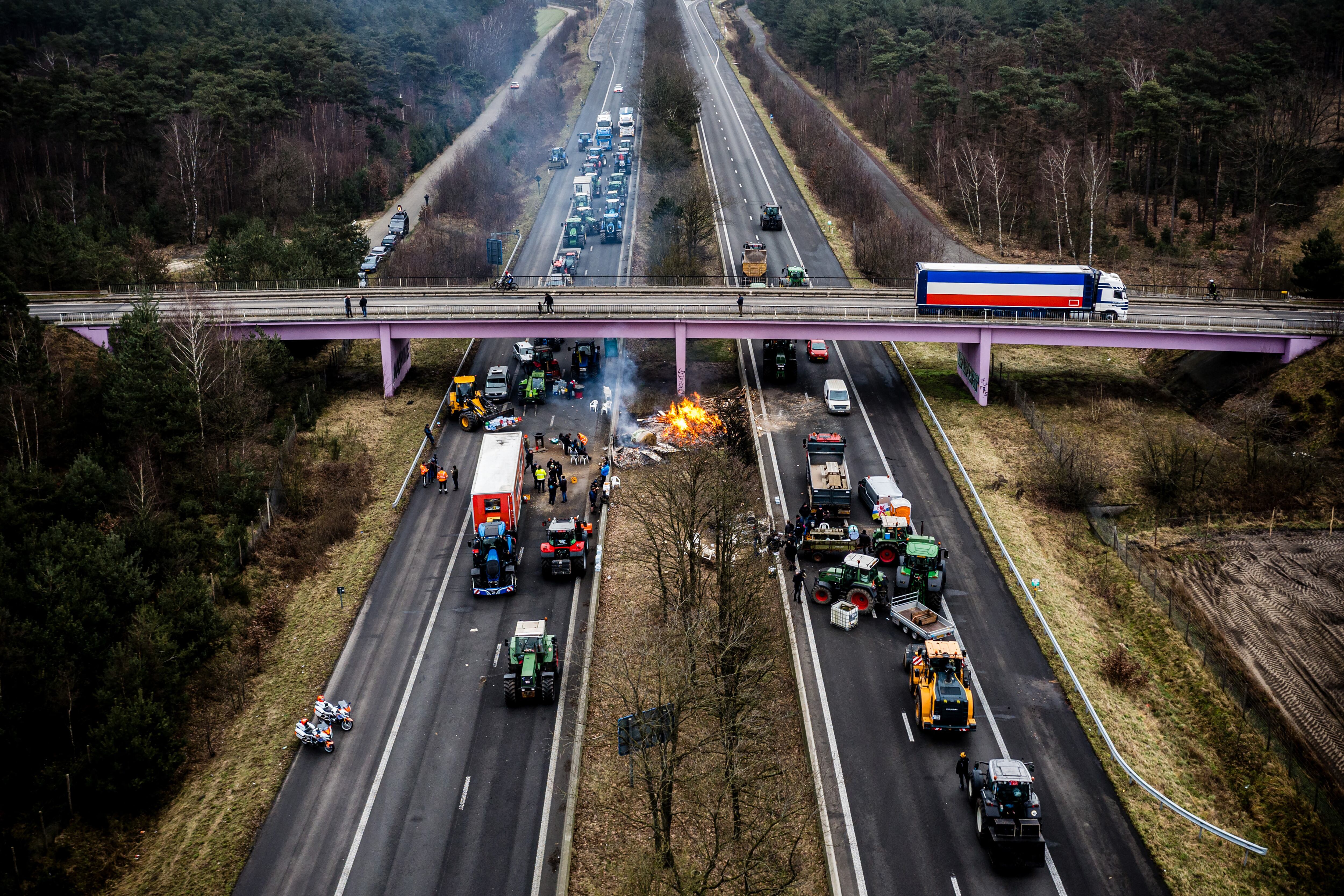This aerial photograph taken on February 2, 2024, shows Dutch and Belgian farmers taking part in a road blockade near the border crossing between Belgium and the Netherlands, in Arendonk, as farmers protest accross Europe to demand better work conditions to grow, produce and maintain a proper income. The farmers are also demonstrating against agricultural rules and regulations that they believe are too strict and unfair competition within European borders. (Photo by ROB ENGELAAR / ANP / AFP) / Netherlands OUT (Photo by ROB ENGELAAR/ANP/AFP via Getty Images)