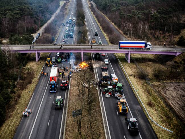 This aerial photograph taken on February 2, 2024, shows Dutch and Belgian farmers taking part in a road blockade near the border crossing between Belgium and the Netherlands, in Arendonk, as farmers protest accross Europe to demand better work conditions to grow, produce and maintain a proper income. The farmers are also demonstrating against agricultural rules and regulations that they believe are too strict and unfair competition within European borders. (Photo by ROB ENGELAAR / ANP / AFP) / Netherlands OUT (Photo by ROB ENGELAAR/ANP/AFP via Getty Images)