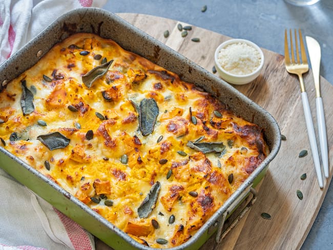 Lasaña en un recipiente sobre una tabla de madera (Foto: Getty Images)