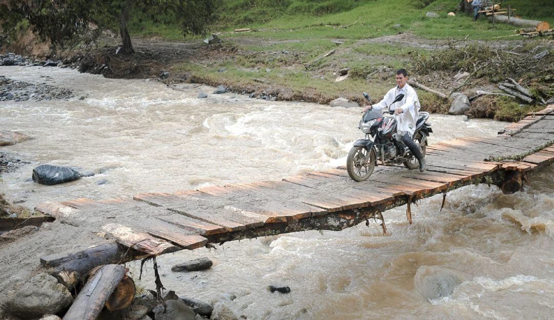Paso de peatones y motos sobre el río Siquila en Planadas, Tolima