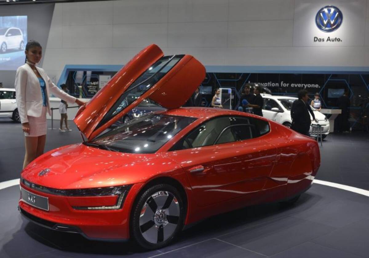 Una modelo posa junto al Volkswagen XL1 expuesto en el 43º Salón del Automóvil deTokio (Japón)