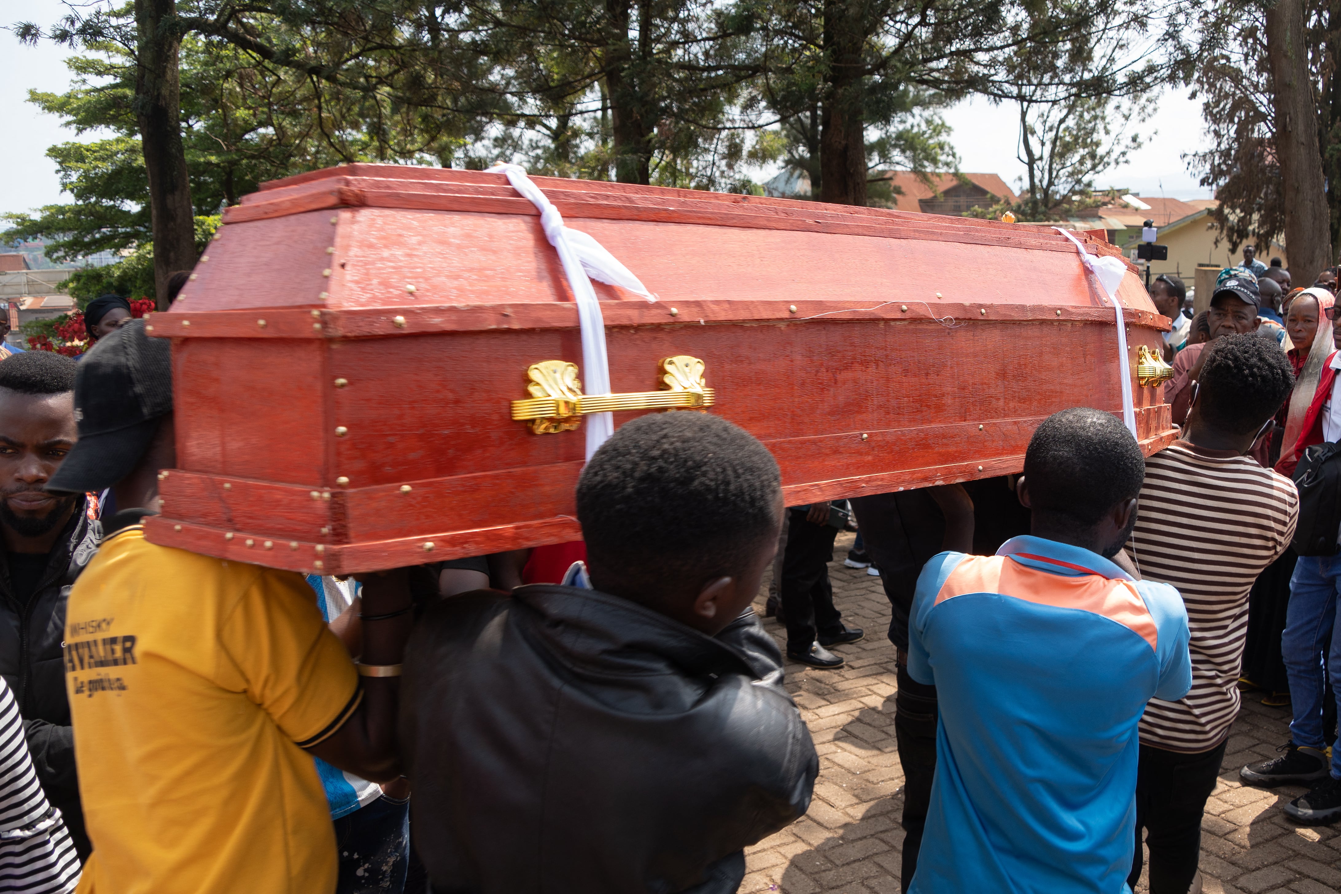Pallbearers carry a coffin in Bukavu on March 4, 2025 during funeral proceedings of victims of the February 27, 2025 explosions at an M23 movement meeting. Two explosions that rocked a city in eastern DR Congo after a meeting of the Rwanda-backed M23 group on February 27, 2025 have killed at least 11 people and wounded around 60, a hospital source told AFP. A first explosion caused panic, sending spectators fleeing, before a second explosion detonated, with pools of blood visible and abandoned shoes strewn across the scene in the city of Bukavu. (Photo by Amani Alimasi / AFP) (Photo by AMANI ALIMASI/AFP via Getty Images)          