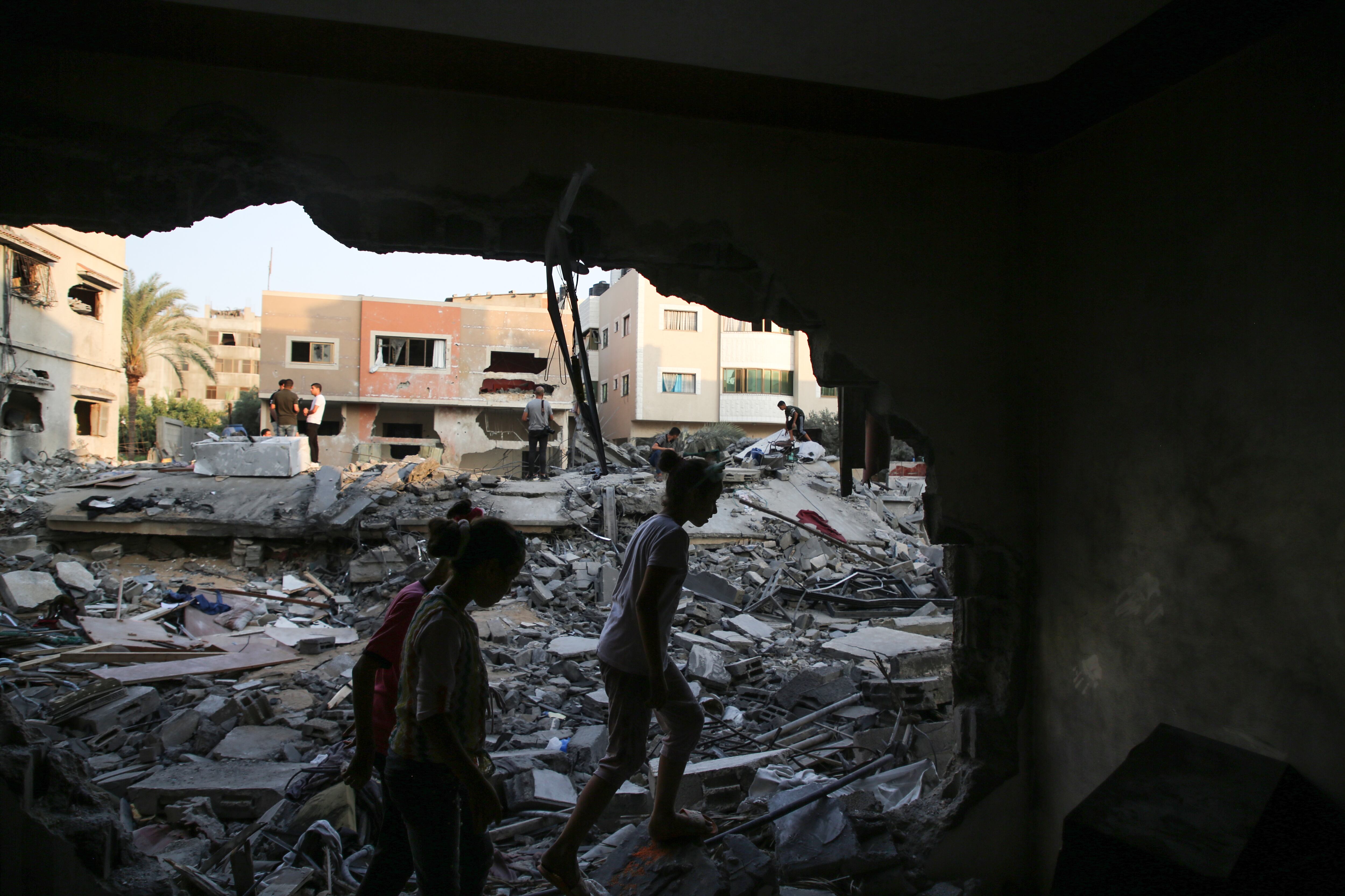 Niños palestinos inspeccionan su edificio dañado en la ciudad de Gaza el 9 de agosto de 2022 después de que entró en vigor un alto el fuego entre Israel y los militantes palestinos. (Photo by Majdi Fathi/NurPhoto via Getty Images)