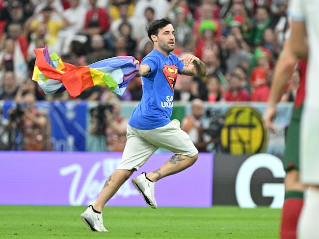LUSAIL, QATAR - NOVEMBER 28: A fan runs on pitch with rainbow flag during the FIFA World Cup Qatar 2022 match between Portugal v Uruguay at the Lusail Stadium on November 28, 2022 in Lusail Qatar (Photo by Lionel Hahn/Getty Images)