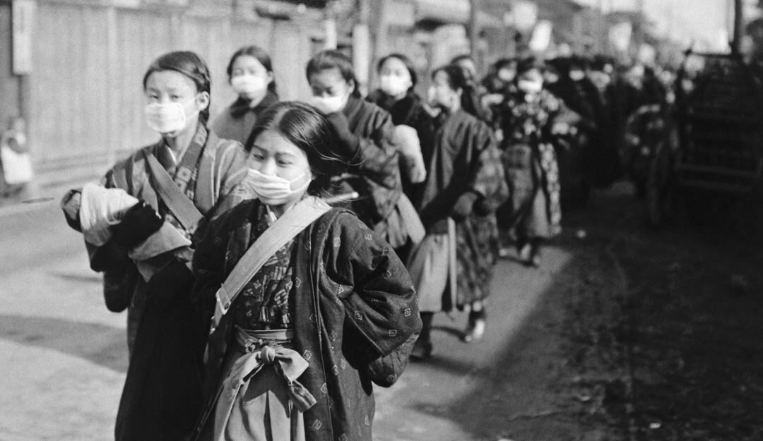 Niñas japonesas utilizan tapabocas para prevenir un brote