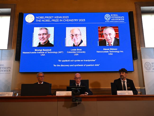 A screen shows this year&#039;s laureates US Chemist Moungi Bawendi, US Chemist Louis Brus and Russian physicist Alexei Ekimov during the announcement of the winners of the 2023 Nobel Prize in chemistry at Royal Swedish Academy of Sciences in Stockholm on October 4, 2023. The trio, whose names were leaked in the Swedish press ahead of the announcement, succeeded in producing these tiny components, that &quot;now spread their light from televisions and LED lamps, and can also guide surgeons when they remove tumour tissue, among many other things,&quot; the jury said. (Photo by Jonathan NACKSTRAND / AFP) (Photo by JONATHAN NACKSTRAND/AFP via Getty Images)