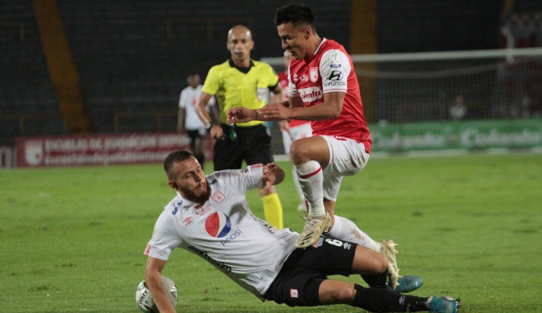 Felipe Jaramillo y Jhon Velásquez disputan un balón durante el juego de la fase regular entre Santa Fe y América.
