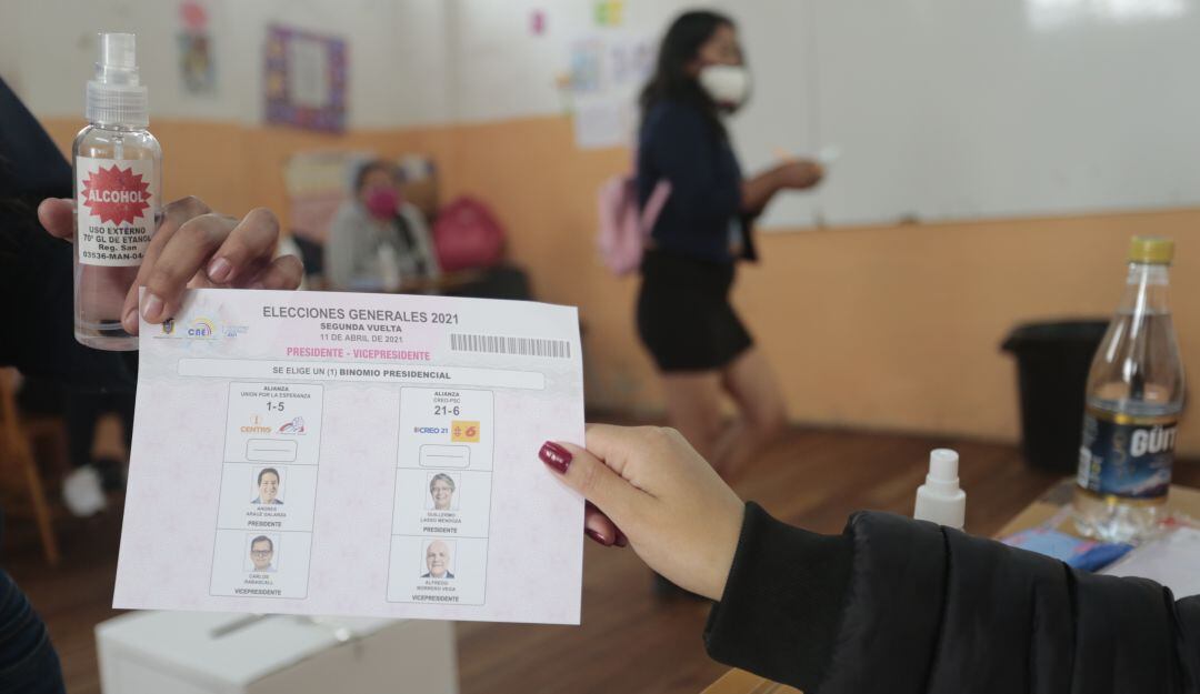 Un votante recibe la tarjeta electoral de las elecciones presidenciales en Quito, Ecuador.