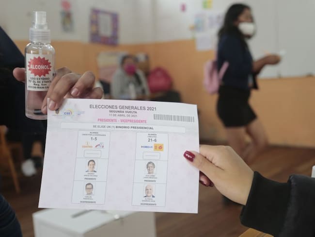 Un votante recibe la tarjeta electoral de las elecciones presidenciales en Quito, Ecuador.