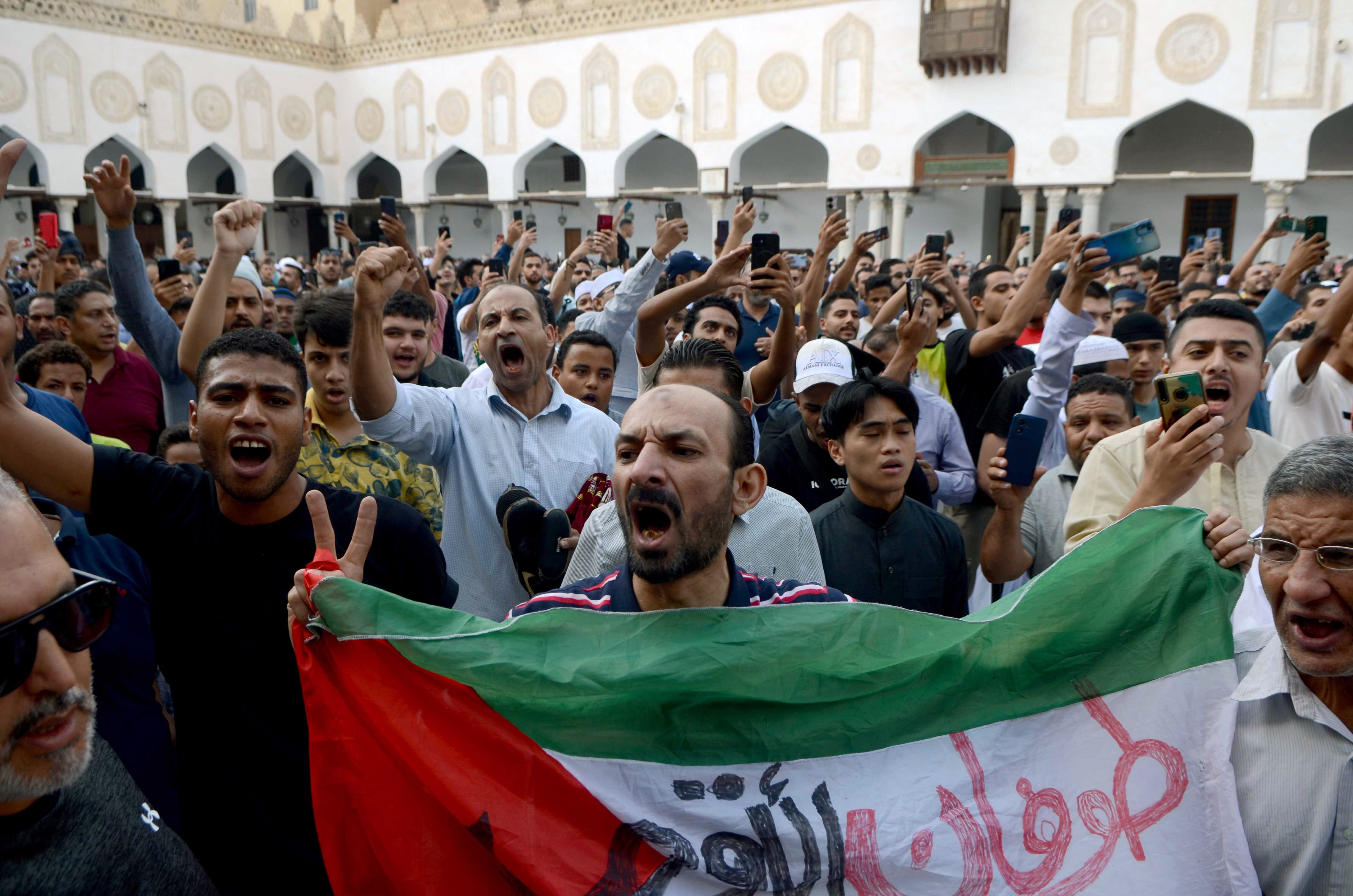 Cairo (Egypt), 13/10/2023.- A protester holds a Palestinian flag as others shout slogans during a protest after Friday prayers at Azhar mosque, in Cairo, Egypt, 13 October 2023. Thousands of Israelis and Palestinians have died since the militant group Hamas launched an unprecedented attack on Israel from the Gaza Strip on 07 October 2023, leading to Israeli retaliation strikes on the Palestinian enclave. (Protestas, Egipto) EFE/EPA/STR