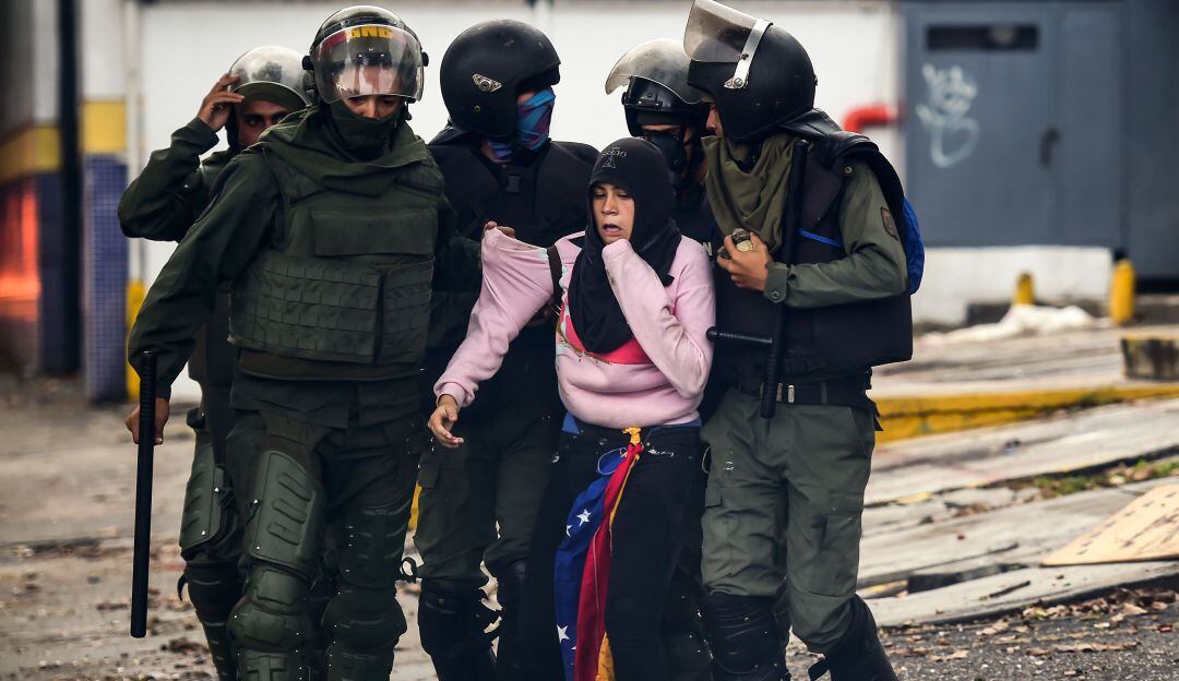 Fuerzas Armadas venezolanas detienen a una manifestante en Caracas. 
