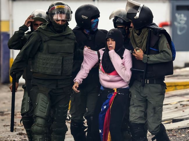 Fuerzas Armadas venezolanas detienen a una manifestante en Caracas. 