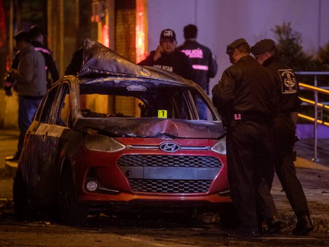 QUI01. QUITO (ECUADOR) 30/08/2023.- Autoridades resguardan la zona donde un vehículo resulto incendiado hoy en Quito (Ecuador). Un coche resultó incendiado y se escucharon al menos cuatro explosiones la noche de este miércoles en una zona comercial de Quito, en un suceso que generó preocupación ante el clima de violencia que se vive en Ecuador. EFE/José Jácome