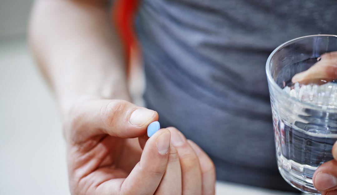 Un hombre tomando una pastilla de viagra