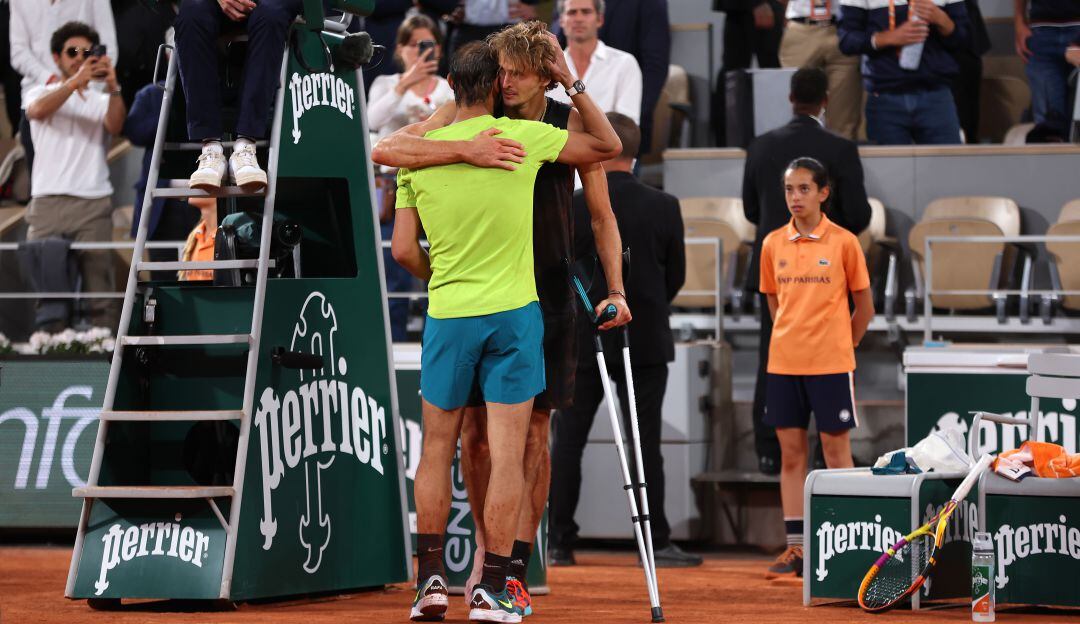 Nadal se abraza con Zverev tras su retiro en muletas del partido.