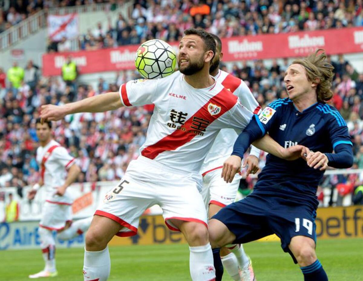 El centrocampista del Real Madrid Luka Modric (d) y Rat Razvan,iz., del Rayo Vallecano, pelean un balón durante el partido correspondiente a la trigésimo quinta jornada de la Liga.