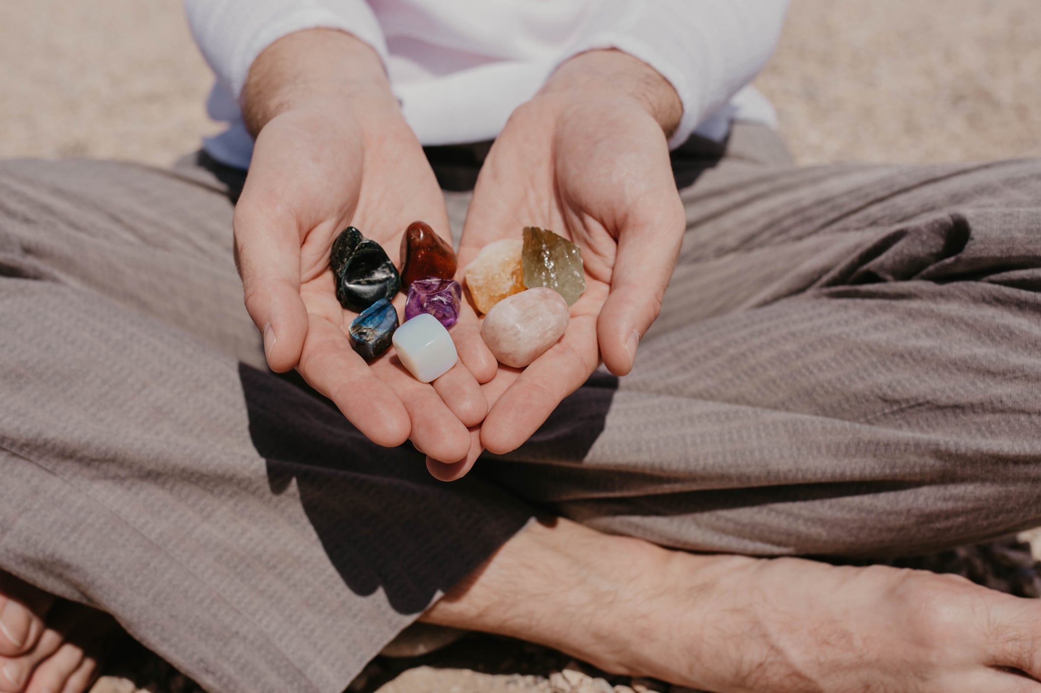 Una persona sentada mientras sostiene varios cuarzos (Foto vía Getty Images)