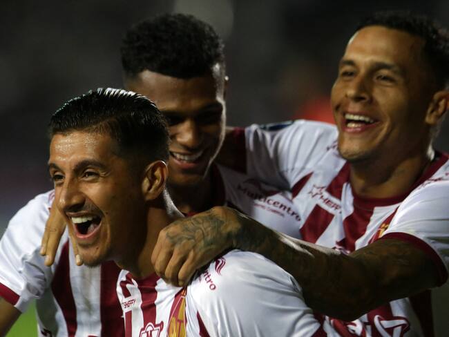 Tolima's midfielder Yeison Guzman (L) celebrates with teammates after scoring during the Copa Sudamericana group stage first leg football match between Puerto Cabello and Deportes Tolima at the Misael Delgado stadium in Valencia, Venezuela on April 6, 2023. (Photo by Juan Carlos HERNANDEZ / AFP) (Photo by JUAN CARLOS HERNANDEZ/AFP via Getty Images)