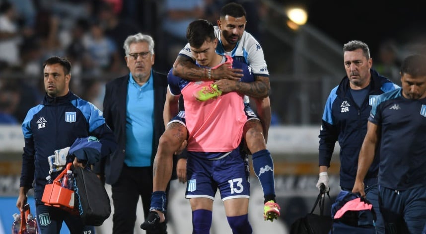 Edwin Cardona es llevado fuera del campo por su compañero Matias Tagliamonte en la derrota de Racing ate Gimnasia Esgrima La Plata. (Photo by Gustavo Garello/Jam Media/Getty Images)