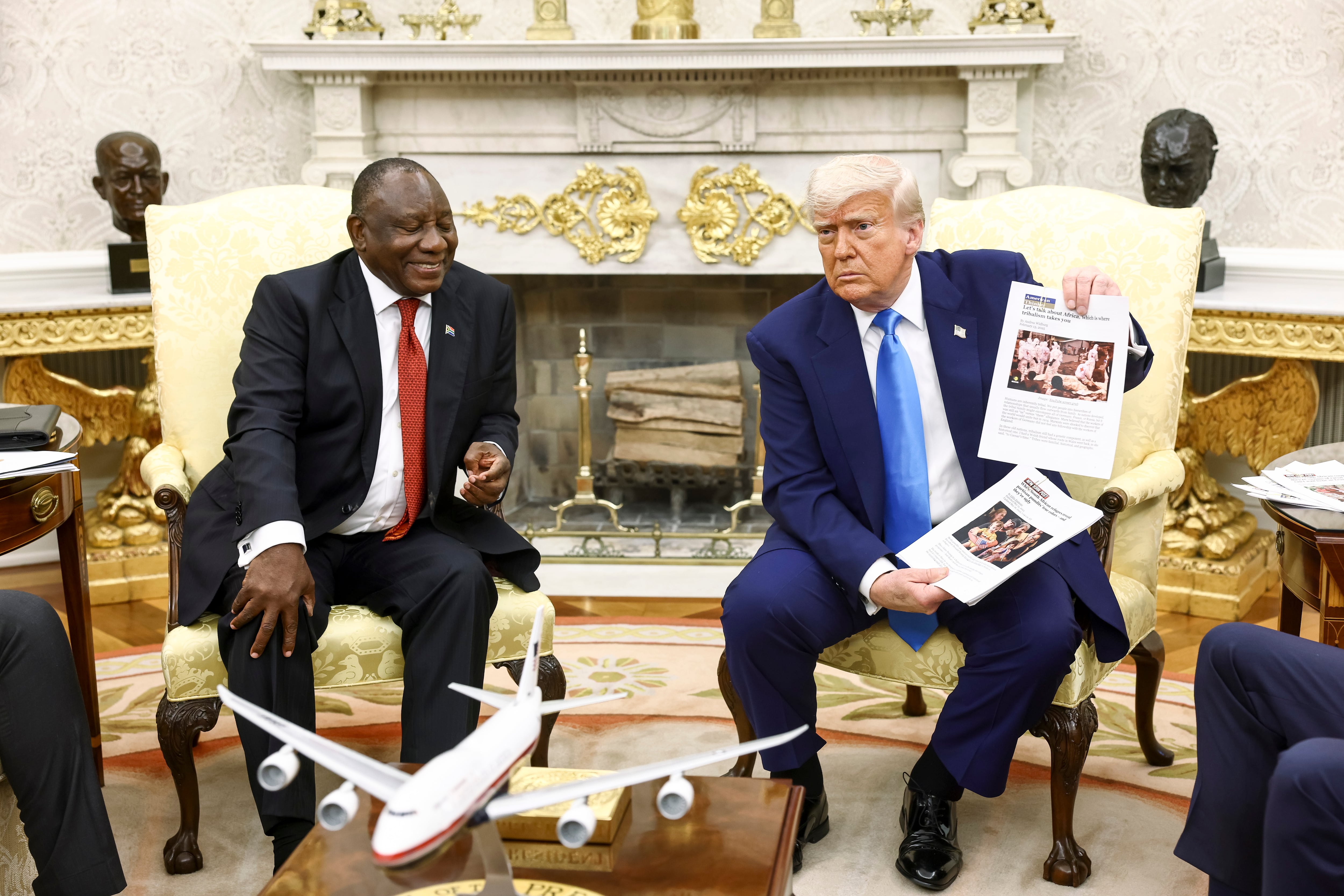 WASHINGTON (United States), 21/05/2025.- US President Donald Trump (R) holds up news articles related to violence in South Africa during a meeting with South Africas President Cyril Ramaphosa (L), in the Oval Office of the White House in Washington, DC, USA, 21 May 2025. Ramaphosas visit comes one week after Trump claimed there is an on-going genocide in South Africa and granted refugee status to 59 Afrikaners. (Sudáfrica) EFE/EPA/JIM LO SCALZO