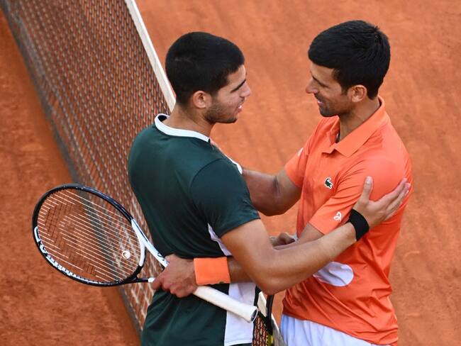 Tenista español Carlos Alcaraz (L) y el serbio Novak Djokovic. (Photo by GABRIEL BOUYS / AFP) (Photo by GABRIEL BOUYS/AFP via Getty Images)