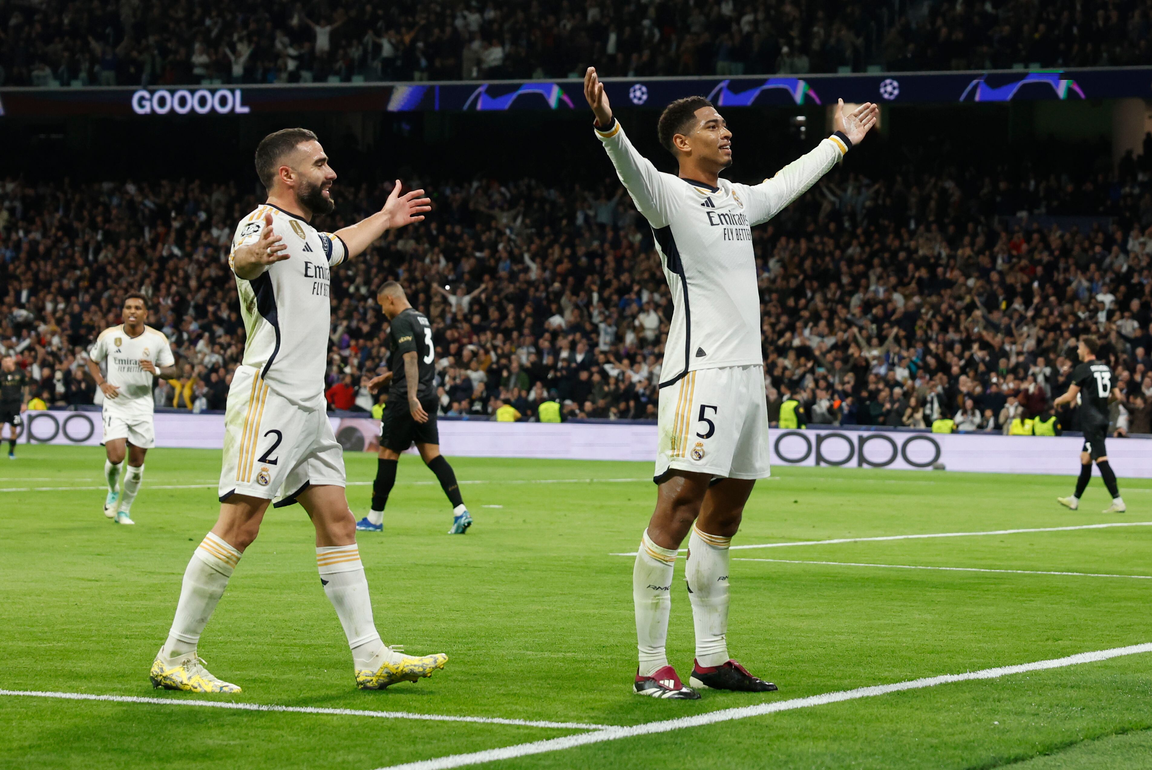 El centrocampista británico del Real Madrid Jude Bellingham, junto a su compañero Carvajal, celebra tras marcar el 2-1 ante el Napoli, durante el partido de la fase de grupos de la Champions League en el estadio Santiago Bernabéu. EFE/Juanjo Martín